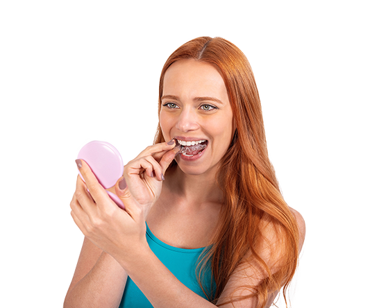 A girl smiling while holding Caspersmile aligners.