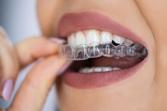 A girl applying invisible aligners for guaranteed results.