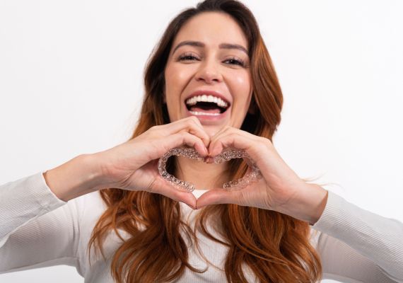 A girl holding Caspersmile invisible braces.