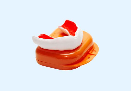 Image of an orange and white mouth guard with its case.