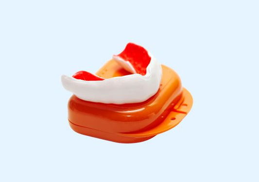 Image of an orange and white mouth guard with its case.