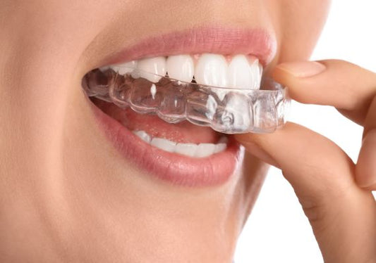 Woman holding clear aligners.