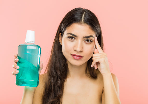An image of a woman holding a mouthwash